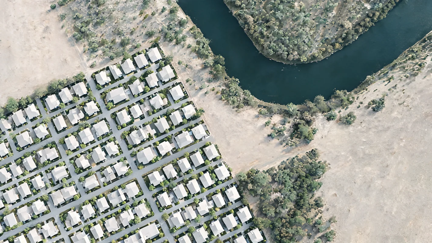 AI-generated conceptual illustration of homes beside a winding river; not a real location